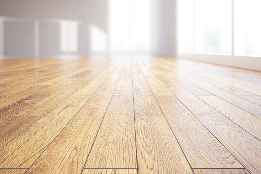 Sol en parquet de bois clair poli avec grain visible, dans un intérieur moderne et lumineux. Arrière-plan flou, murs blancs.