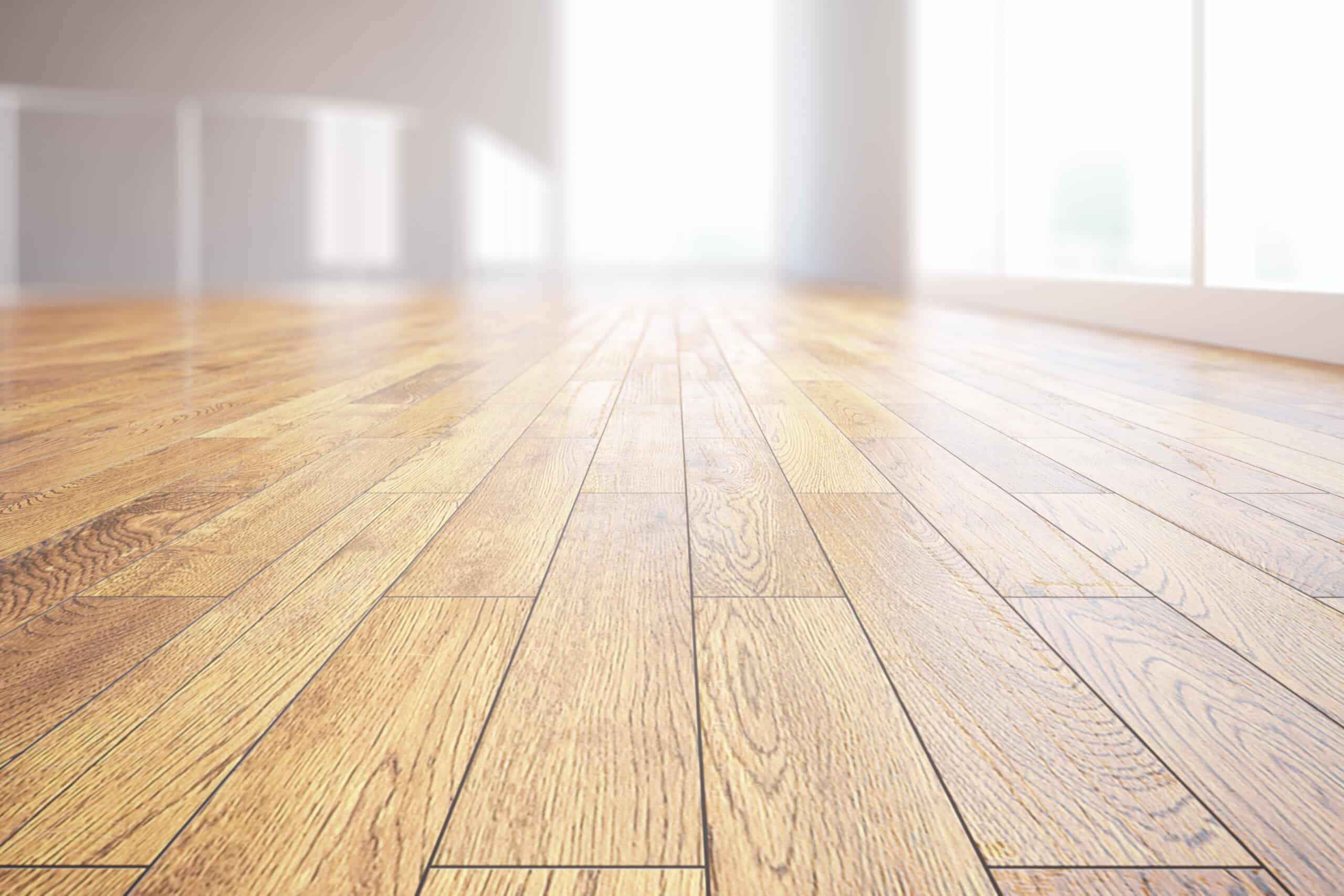 Sol en parquet de bois clair poli avec grain visible, dans un intérieur moderne et lumineux. Arrière-plan flou, murs blancs.